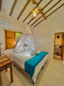 a bedroom with a bed with a mosquito net at Villa Milagre in Trancoso