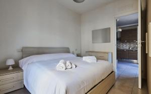 a bedroom with a bed with two pairs of slippers at Affitti Brevi Liguria - Casamare in Varazze