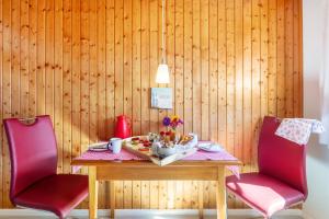 a table with two chairs and a table with food on it at Haus Am Bühl in Schönau im Schwarzwald