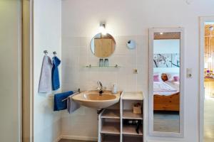 a bathroom with a sink and a mirror and a bed at Haus Am Bühl in Schönau im Schwarzwald