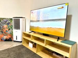 a flat screen tv sitting on a wooden tv stand at Big apartment Yaoundé 2 rooms in Yaoundé