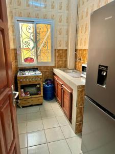 a small kitchen with a stove and a window at Big apartment Yaoundé 2 rooms in Yaoundé