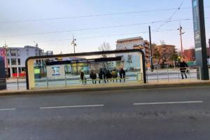 Una parada de autobús con gente caminando por una calle de la ciudad. en Orly Express - Confort à Deux Pas de l'Aéroport, en Orly