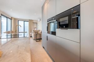 a living room with a kitchen with a tv at Málaga Benalmádena Vacation Rentals five minutes from the Port of Benalmádena Beach Pool and Sun in Benalmadena Costa