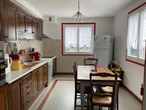 a kitchen with a table and chairs and a refrigerator at Maison familiale au cœur des Pyrénées ! in Argelès-Gazost