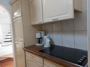a kitchen with white cabinets and a coffee maker on a counter at Singelachterhuis Roermond in Roermond