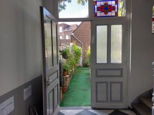 an open door to a yard with a green lawn at Singelachterhuis Roermond in Roermond