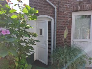 a white door leading to a brick building at Singelachterhuis Roermond in Roermond