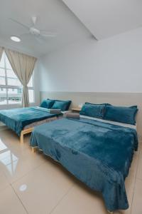 two beds in a bedroom with blue sheets at kings Pine Residences Homestay kundasang Ranau 17 in Ranau