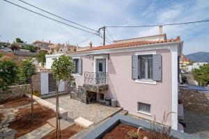 a pink house with a balcony and a yard at Koilada Family House 1 in Koilás