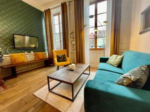 un salon avec un canapé bleu et une table dans l'établissement Appartement F2, "La Scène du 66", VERDUN CENTRE, Garage motos et vélo, WIFI, Géré par PrestaZen'Services, à Verdun-sur-Meuse