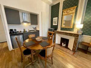 une salle à manger avec une table et une cheminée dans l'établissement Appartement F2, "La Scène du 66", VERDUN CENTRE, Garage motos et vélo, WIFI, Géré par PrestaZen'Services, à Verdun-sur-Meuse 17 autres photos