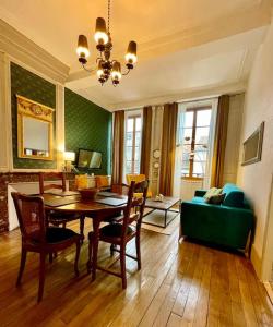 - un salon avec une table et un canapé vert dans l'établissement Appartement F2, "La Scène du 66", VERDUN CENTRE, Garage motos et vélo, WIFI, Géré par PrestaZen'Services, à Verdun-sur-Meuse