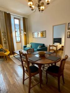 un salon avec une table, des chaises et un canapé dans l'établissement Appartement F2, "La Scène du 66", VERDUN CENTRE, Garage motos et vélo, WIFI, Géré par PrestaZen'Services, à Verdun-sur-Meuse