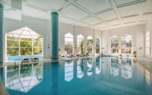 an indoor pool with blue water in a large room with windows at Marhaba Royal Salem - Family Only in Sousse