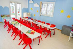 a classroom with white tables and red chairs at Marhaba Royal Salem - Family Only in Sousse