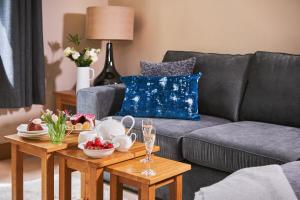 ein Wohnzimmer mit einem grauen Sofa und einem Couchtisch in der Unterkunft Swifts Return - Apartment with hot tub, sauna and indoor pool (Dartmoor) in Trusham