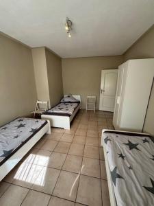 NiederrodenbachにあるSunrise Monteur Apartmentのベッド2台と椅子2脚が備わる客室です。