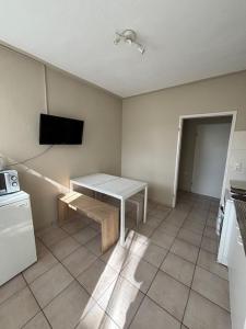 NiederrodenbachにあるSunrise Monteur Apartmentのキッチン(テーブル、壁掛けテレビ付)