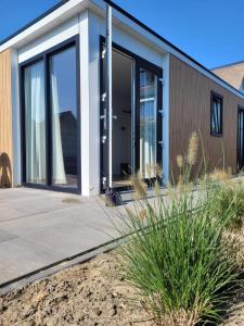 una casa con grandes puertas de cristal en un lateral en Vakantiehuis Huisje 31 Zoutelande, en Zoutelande