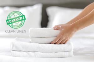 a woman is stacking towels on a bed at Medulić Palace Rooms & Apartments in Šibenik