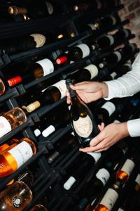 a person holding a bottle of wine in a wine cellar at Hotel de Naaldhof in Oss +37 photos