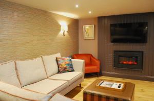 a living room with a couch and a fireplace at The Lawrance Luxury Aparthotel - Harrogate in Harrogate