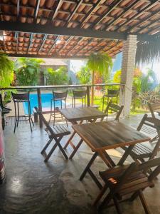 a group of wooden tables and chairs on a patio at Casa Kuki's in Pipa +133 photos