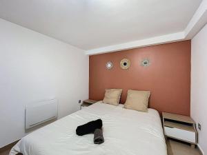 a bedroom with a bed with a black hat on it at Évasion Verte - Jardin & Confort in Dunkerque