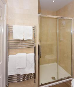 a bathroom with a shower with towels on a towel rack at Ashville House in Killarney