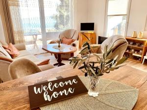 a living room with a welcome home sign on a table at Chalet Elli's Mountain View in Velje Selo