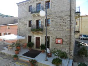 een bakstenen gebouw met een tafel en een paraplu bij La Casa Di Babbai in Nuchis