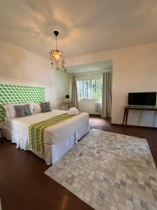 a bedroom with two beds and a flat screen tv at Les Jardins de Rio in Rio de Janeiro +50 photos