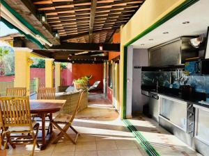 an outdoor kitchen with a wooden table and chairs at Maison conviviale à Fréjus avec piscine à débordement in Fréjus