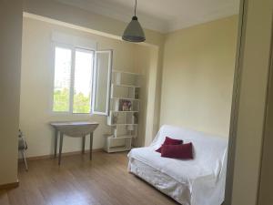 Un dormitorio con una cama blanca y una ventana. en Cozy Appartement - Lumineux 3 pièces, à côté du Jardin de Turia, en Valencia