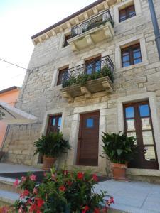 a stone building with potted plants in front of it at La Casa Di Babbai in Nuchis