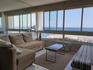 a living room with a couch and a table at Appart vue d'exception sur la mer in Bandol