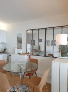 a kitchen and dining room with a glass table and chairs at Appart vue d'exception sur la mer in Bandol +18 photos