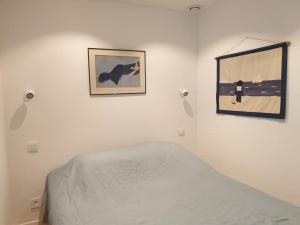 邦多勒Appart vue d'exception sur la mer的卧室里有一张床，墙上挂着两幅画