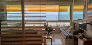 a living room with a large window with blinds at Appart vue d'exception sur la mer in Bandol