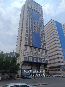 a tall building with writing on the side of it at فندق مناير الاصول in Al Khansāk