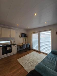 a kitchen and living room with a couch and a table at Tiny House im Felsenland mit Sauna in Lug