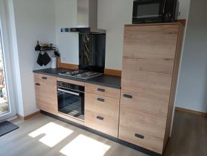 a kitchen with a large wooden cabinet with a stove at L'elydiane in Hundling