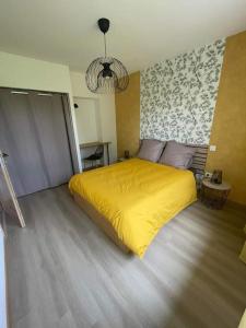 a bedroom with a bed with a yellow blanket at L'elydiane in Hundling