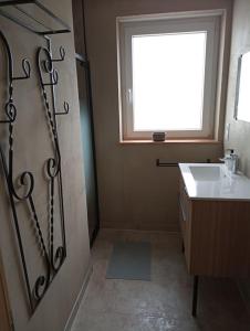 a bathroom with a sink and a window at L'elydiane in Hundling