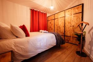 a bedroom with a bed with a red curtain at Le Secret du Château in Beyren-lès-Sierck