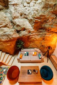 a living room with a couch and a stone wall at Le Secret du Château in Beyren-lès-Sierck