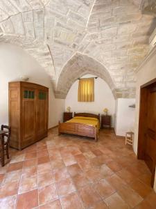 a bedroom with a bed and a stone ceiling at Masseria Montanari in Carpignano Salentino