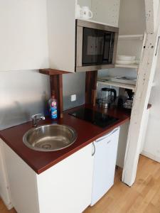 eine Küche mit Spüle und Mikrowelle in der Unterkunft Monteurwohnung für 2 Personen inkl. MwSt. - DG Wohnung in Brunsbüttel + 2 Fotos