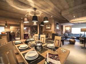 a dining room and living room with a table and chairs at Chalet moderne 5* à Courchevel La Tania - 12 pers, jacuzzi, sauna, skis aux pieds, cheminée, cinéma - FR-1-575-154 in Courchevel